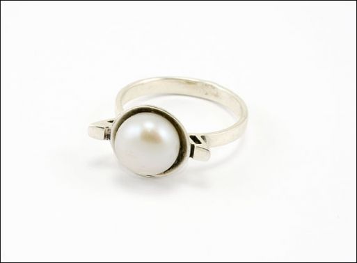 Кольцо с жемчугом в серебре выполнено в классическом стиле.