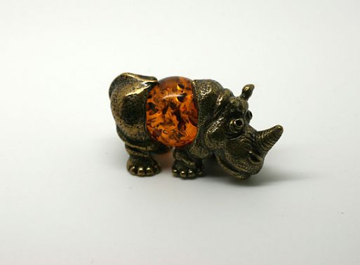 Бронзовую фигурку с янтарем носорог 44567 купить в магазине Самоцветы мира