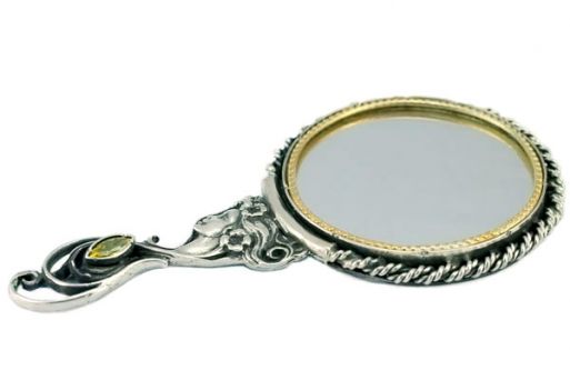 Серебряное зеркальце диаметром 55 мм с ручкой в виде женского профиля.